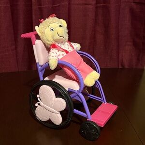 Pink and Purple Stuffed Animal on Toy Wheelchair